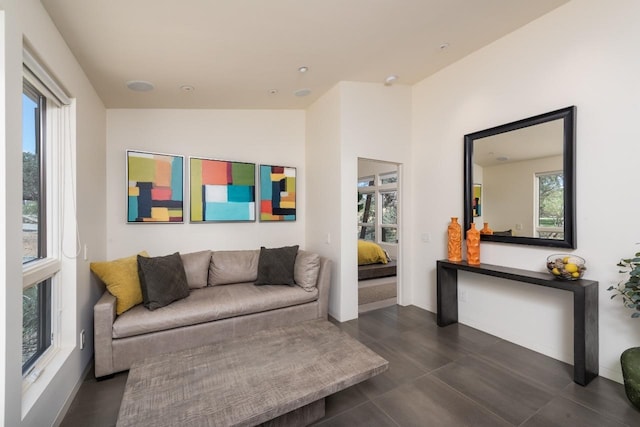 living room with lofted ceiling, baseboards, and a healthy amount of sunlight