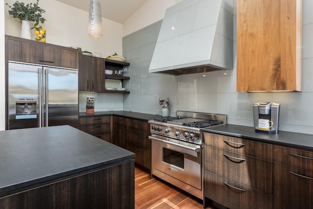 kitchen with open shelves, tasteful backsplash, dark countertops, wall chimney exhaust hood, and high end appliances