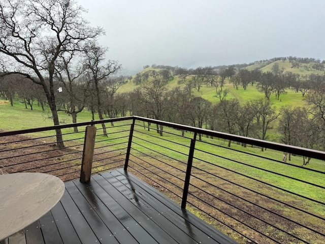 wooden terrace with a lawn and a rural view