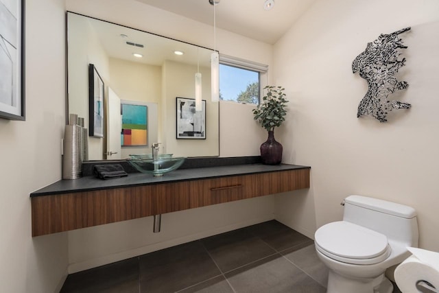 bathroom featuring toilet, tile patterned flooring, vanity, and baseboards