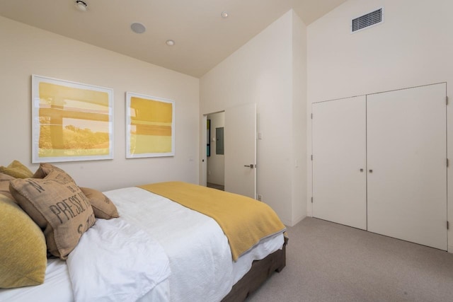 bedroom featuring visible vents, light colored carpet, electric panel, a closet, and high vaulted ceiling