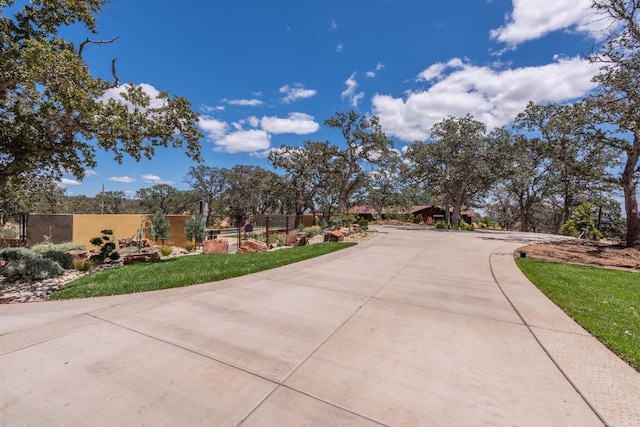 exterior space with a front lawn, fence, and driveway