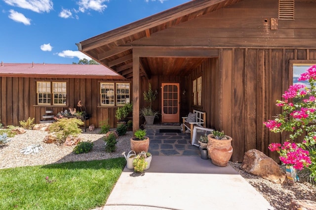 doorway to property featuring board and batten siding and visible vents