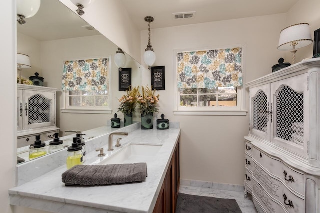 bathroom featuring vanity, baseboards, and visible vents