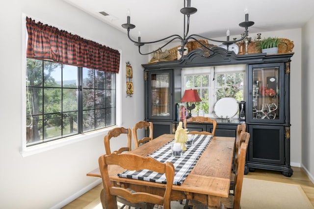 dining room featuring light wood finished floors, visible vents, and baseboards