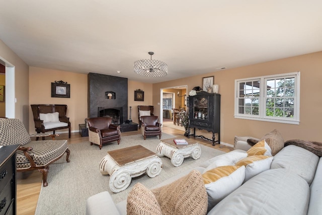 living area with a fireplace, baseboards, and wood finished floors