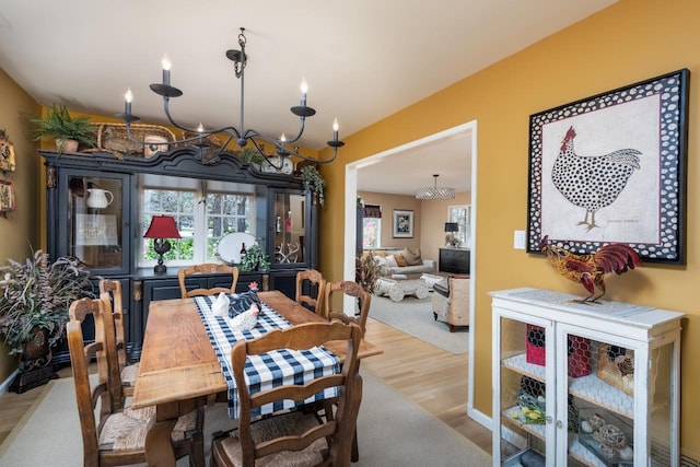 dining space with a notable chandelier and wood finished floors