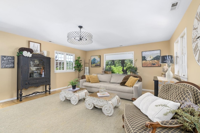 living area featuring visible vents, wood finished floors, and baseboards