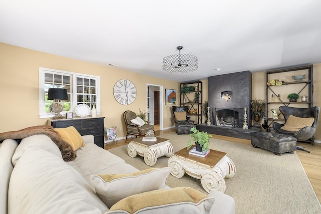 living room with a fireplace, baseboards, visible vents, and wood finished floors