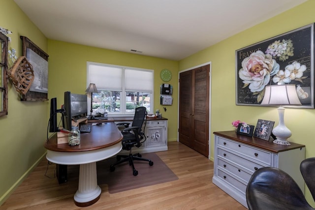 office space featuring wood finished floors, visible vents, and baseboards