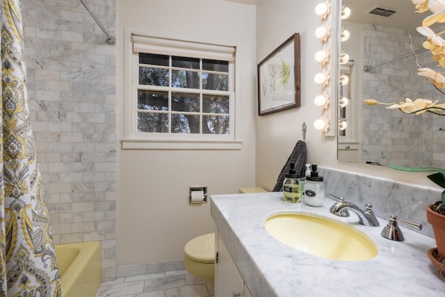 full bathroom featuring toilet, marble finish floor, vanity, visible vents, and shower / tub combo