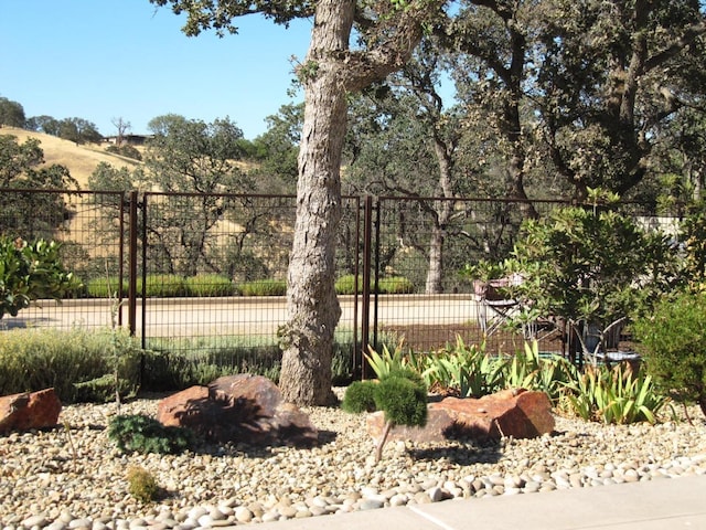 view of tennis court featuring a gate and fence