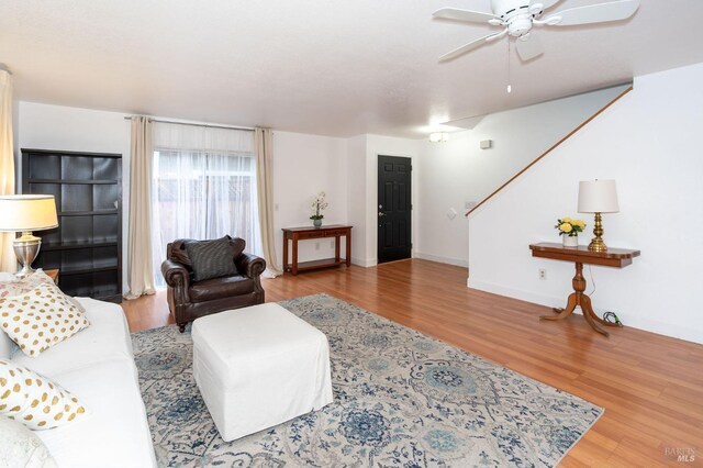 living room with hardwood / wood-style flooring and ceiling fan