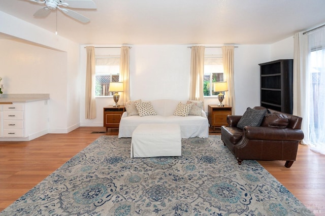 living room featuring ceiling fan, a healthy amount of sunlight, and light wood-type flooring