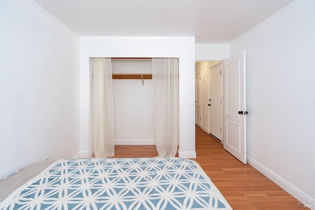 bedroom with hardwood / wood-style floors and a closet