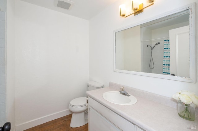 bathroom featuring vanity, hardwood / wood-style floors, a shower with curtain, and toilet