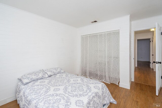 bedroom featuring hardwood / wood-style floors and a closet