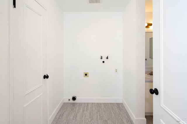 laundry area with washer hookup, hookup for an electric dryer, and light hardwood / wood-style flooring