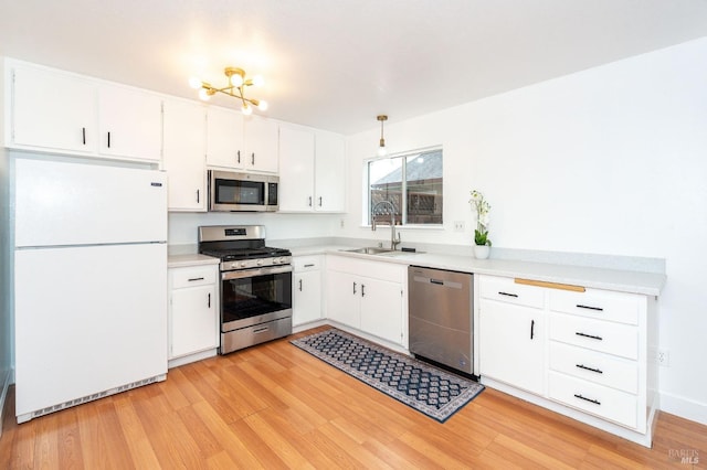 kitchen featuring sink, light hardwood / wood-style flooring, stainless steel appliances, and white cabinets