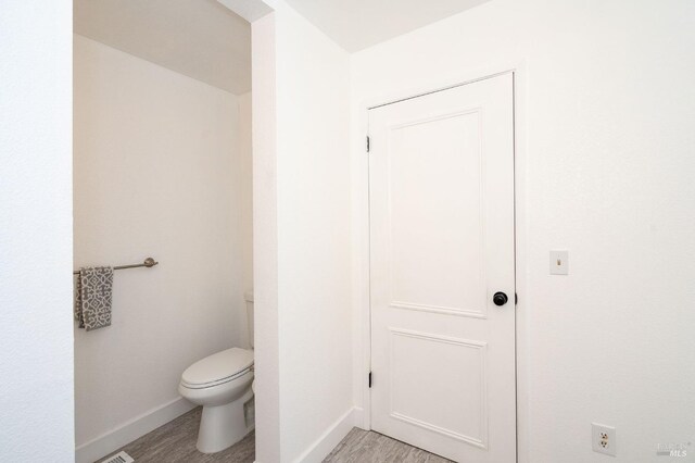 bathroom with wood-type flooring and toilet