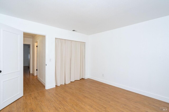 unfurnished bedroom featuring hardwood / wood-style flooring and a closet