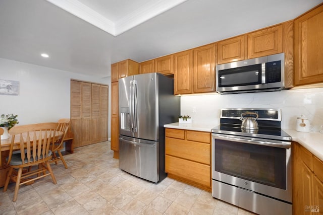 kitchen with a tray ceiling, decorative backsplash, stainless steel appliances, and crown molding