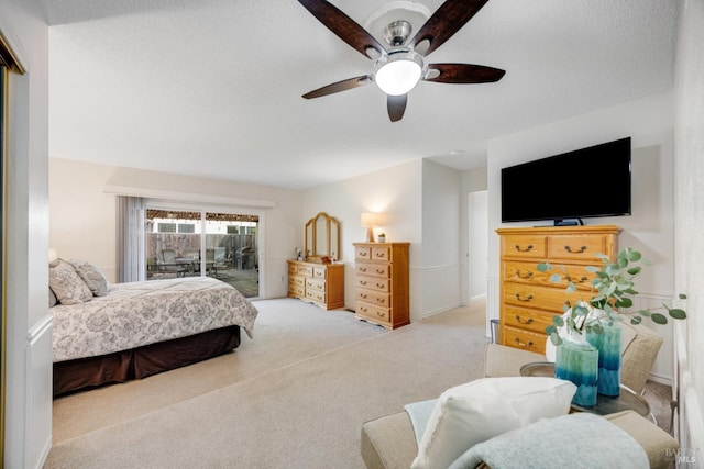 carpeted bedroom with access to exterior, a textured ceiling, and ceiling fan