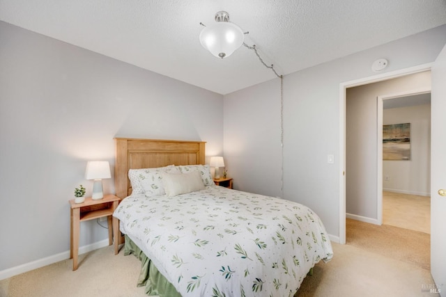 bedroom with light carpet and a textured ceiling