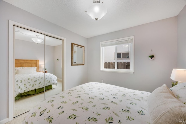 carpeted bedroom featuring a textured ceiling and a closet