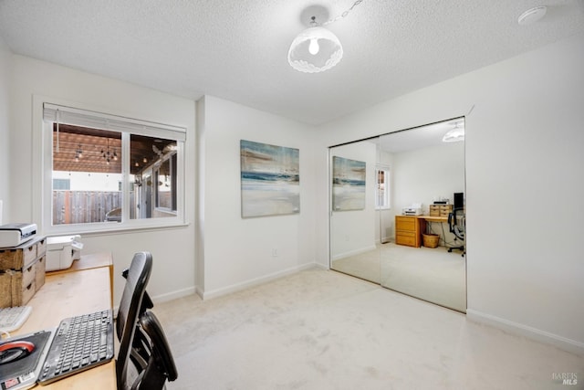 home office featuring a textured ceiling and carpet flooring