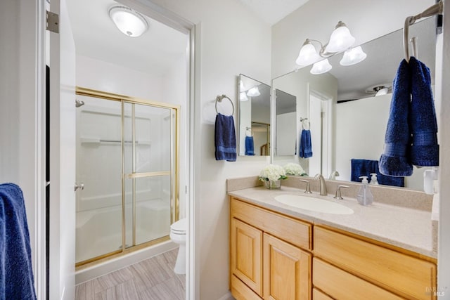 bathroom featuring an enclosed shower, vanity, and toilet