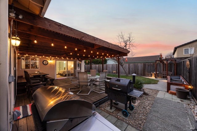 patio terrace at dusk featuring grilling area