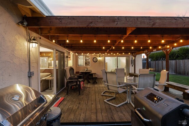 deck at dusk featuring area for grilling