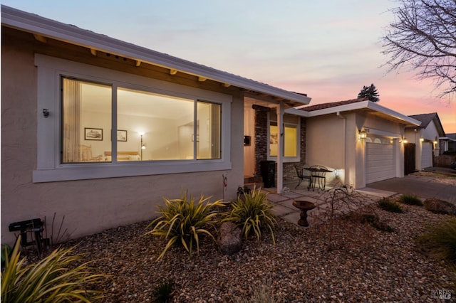 view of front of home with a garage and a patio