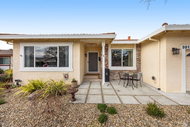 view of exterior entry with a patio