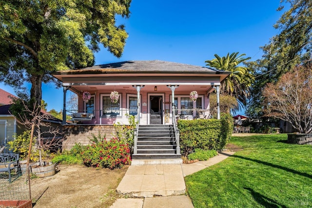 bungalow featuring covered porch and a front lawn