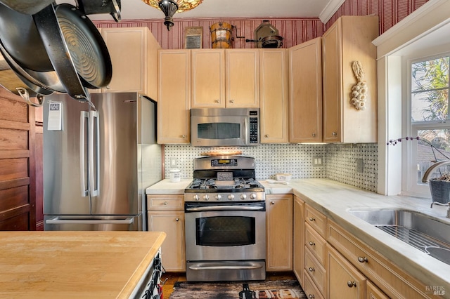 kitchen with light brown cabinetry, sink, and stainless steel appliances