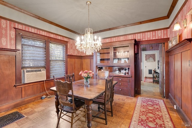 dining room featuring light parquet floors, crown molding, cooling unit, and a notable chandelier