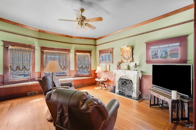 living room with hardwood / wood-style floors, crown molding, a wealth of natural light, and ceiling fan