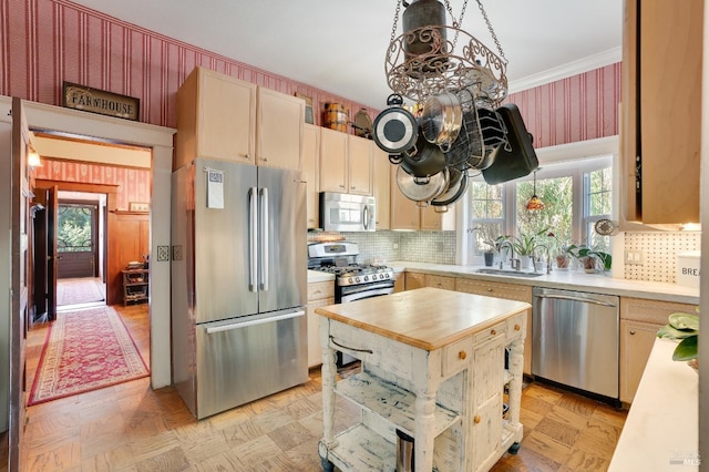 kitchen featuring light parquet flooring, stainless steel appliances, sink, and light brown cabinets