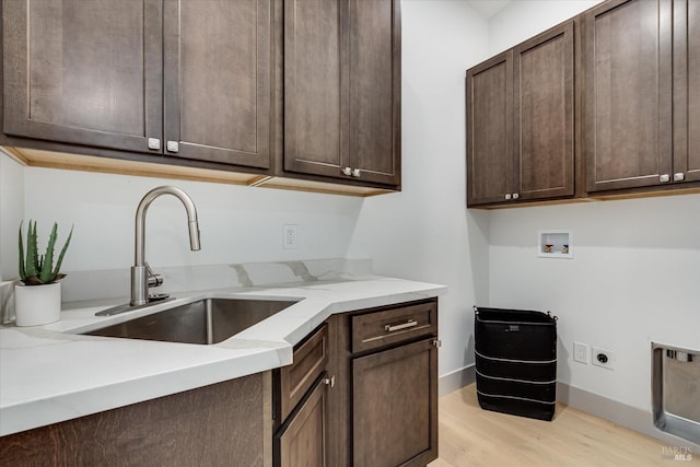 washroom featuring sink, cabinets, light wood-type flooring, washer hookup, and hookup for an electric dryer