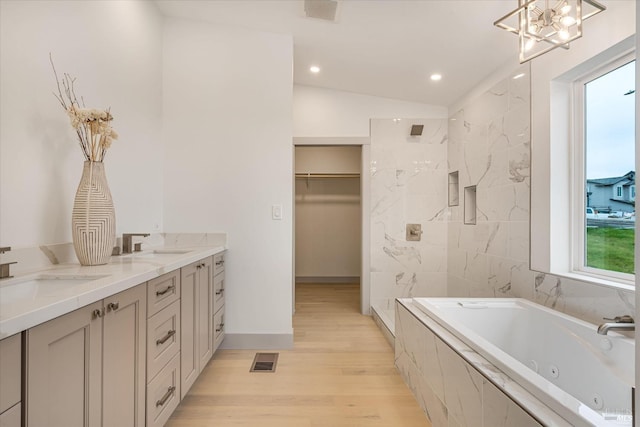 bathroom featuring vanity, shower with separate bathtub, wood-type flooring, and lofted ceiling