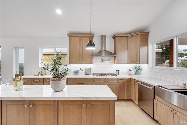 kitchen featuring tasteful backsplash, light stone countertops, appliances with stainless steel finishes, and wall chimney exhaust hood