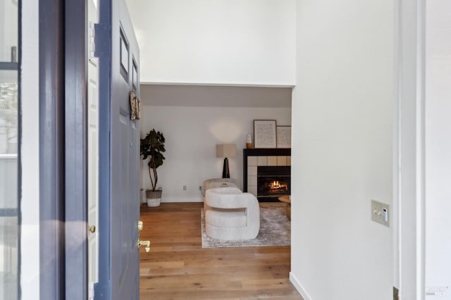 entrance foyer featuring a tiled fireplace and light hardwood / wood-style floors