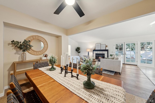 living room with hardwood / wood-style floors, a tile fireplace, french doors, and ceiling fan