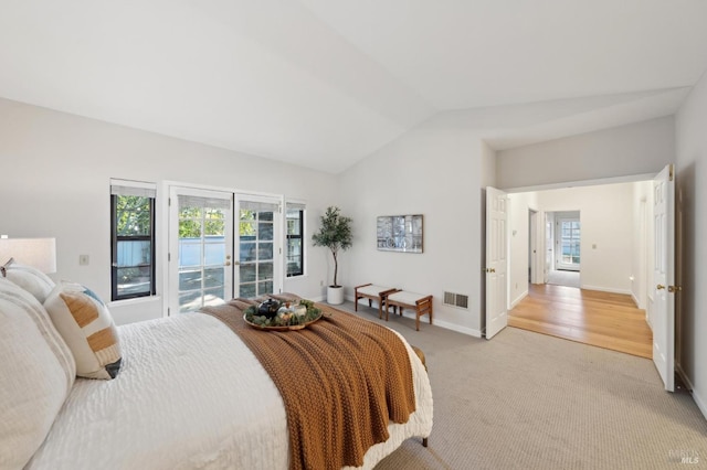 bedroom featuring vaulted ceiling, access to outside, light colored carpet, and french doors