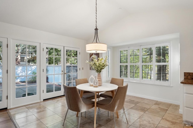 dining area with light tile patterned flooring and lofted ceiling