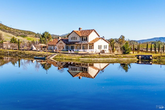 back of house featuring a water and mountain view