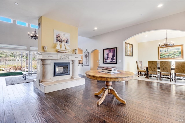 living room featuring a notable chandelier, hardwood / wood-style flooring, and a tile fireplace