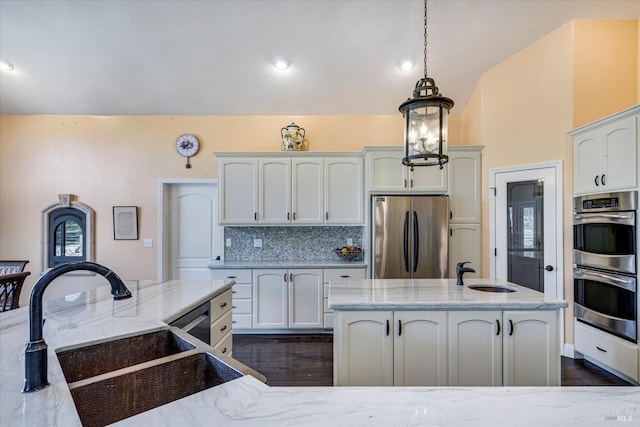 kitchen featuring hanging light fixtures, stainless steel appliances, sink, and white cabinets